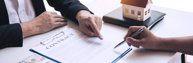 buyer signing real estate contract with real estate lawyer