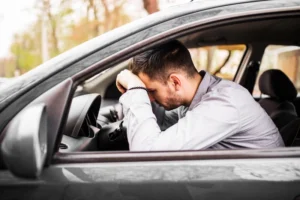 At-fault driver has no insurance rests his head on the steering whee
